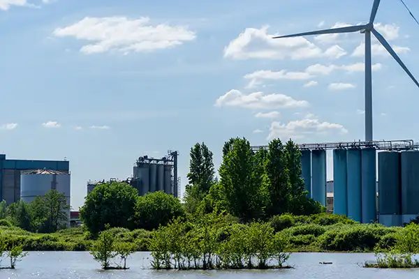 Photo d'un site industriel entouré de végétation pour illustrer la réduction des émissions de gaz à effet de serre